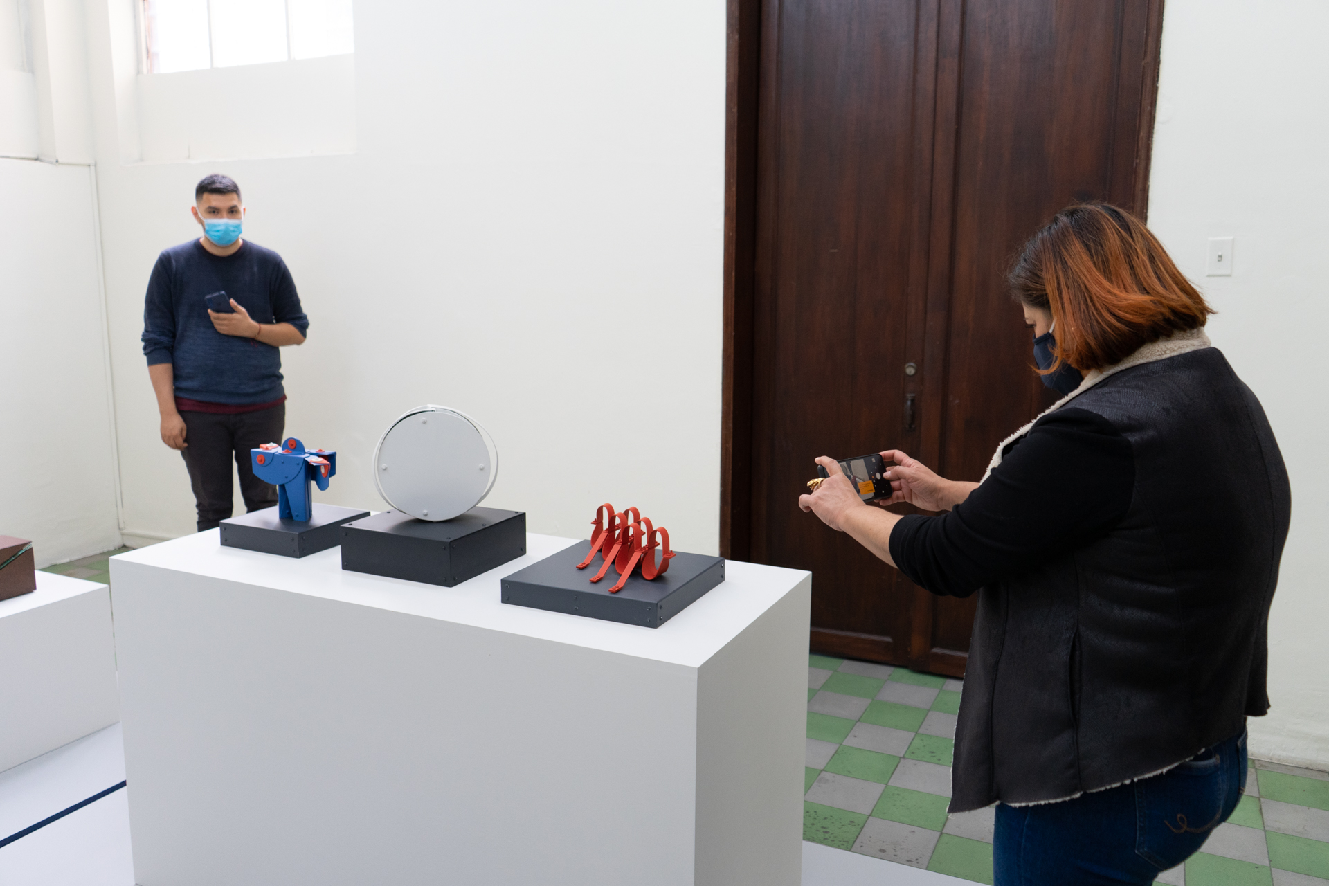 una mujer tomándoles una foto a una escultura