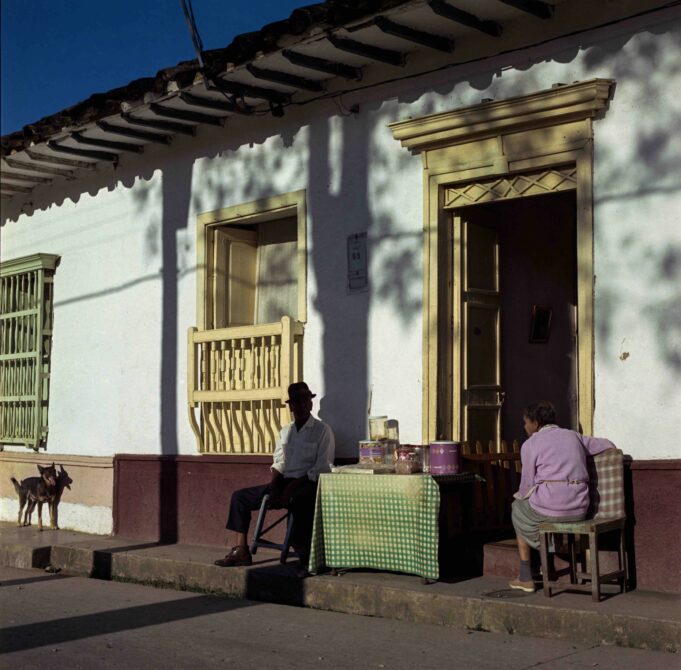 dos personas sentadas en las afueras de una casa