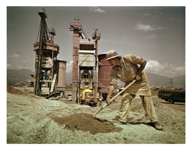 Hombre escavando con una pala en el cemento