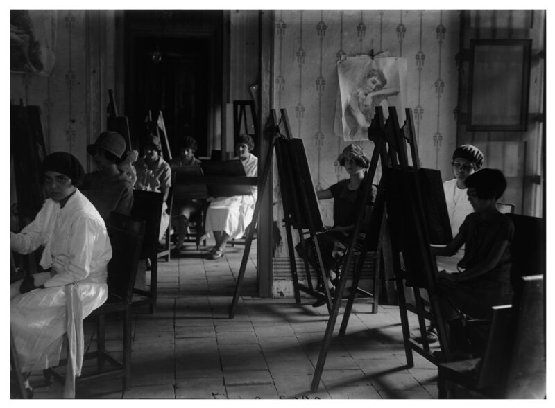 grupo de mujeres pintando cuadros en una habitación